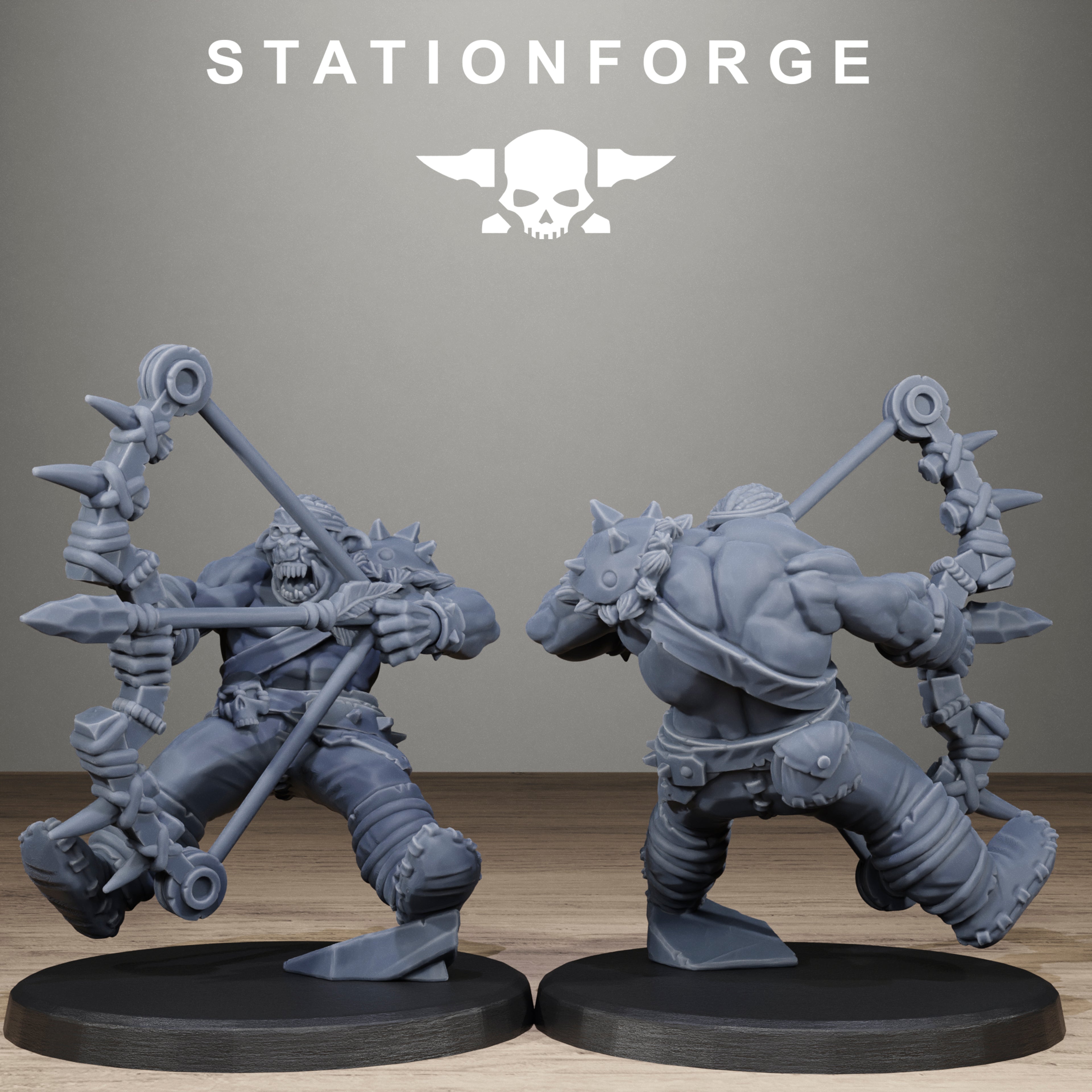 Two gray fantasy warrior figurines on black bases with Stationforge logo in the background.